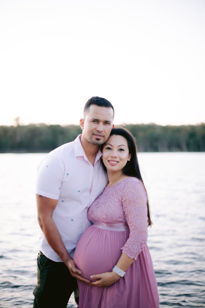 A Couple Posing Outside at a Pregnancy Photoshoot.