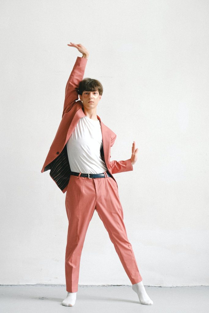 A Man Dancing in a pastel pink suit.