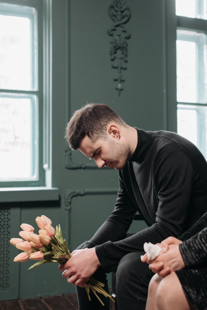 A Man Sitting on the Bench in a black turtleneck sweater.