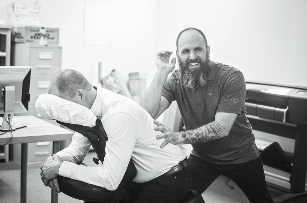 bearded man giving a chair massage.