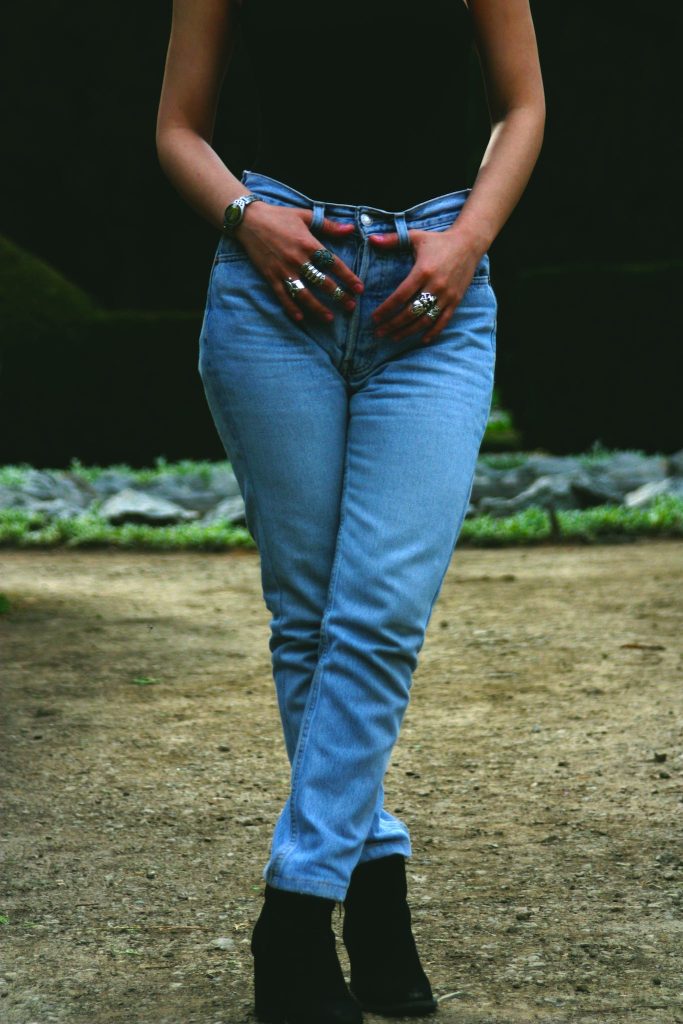 crop of Woman Holding Her Jeans from stomach down.