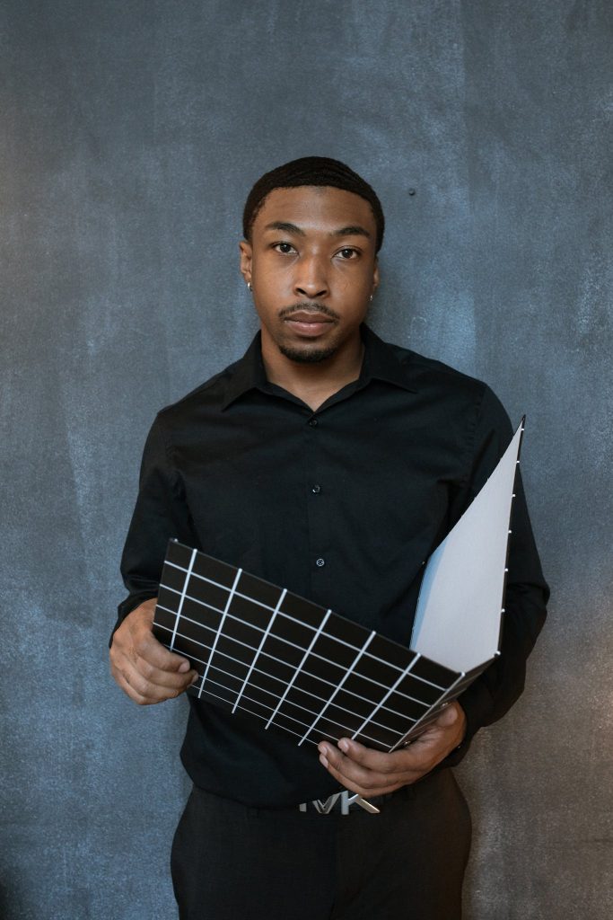 Man in Black Dress Shirt Holding Blue and White Checked Textile.